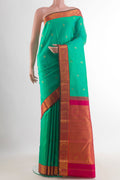 Pure Silk Green Kanchipuram Saree with Zari Butta on the body and Zari Border.  displayed on a mannequin