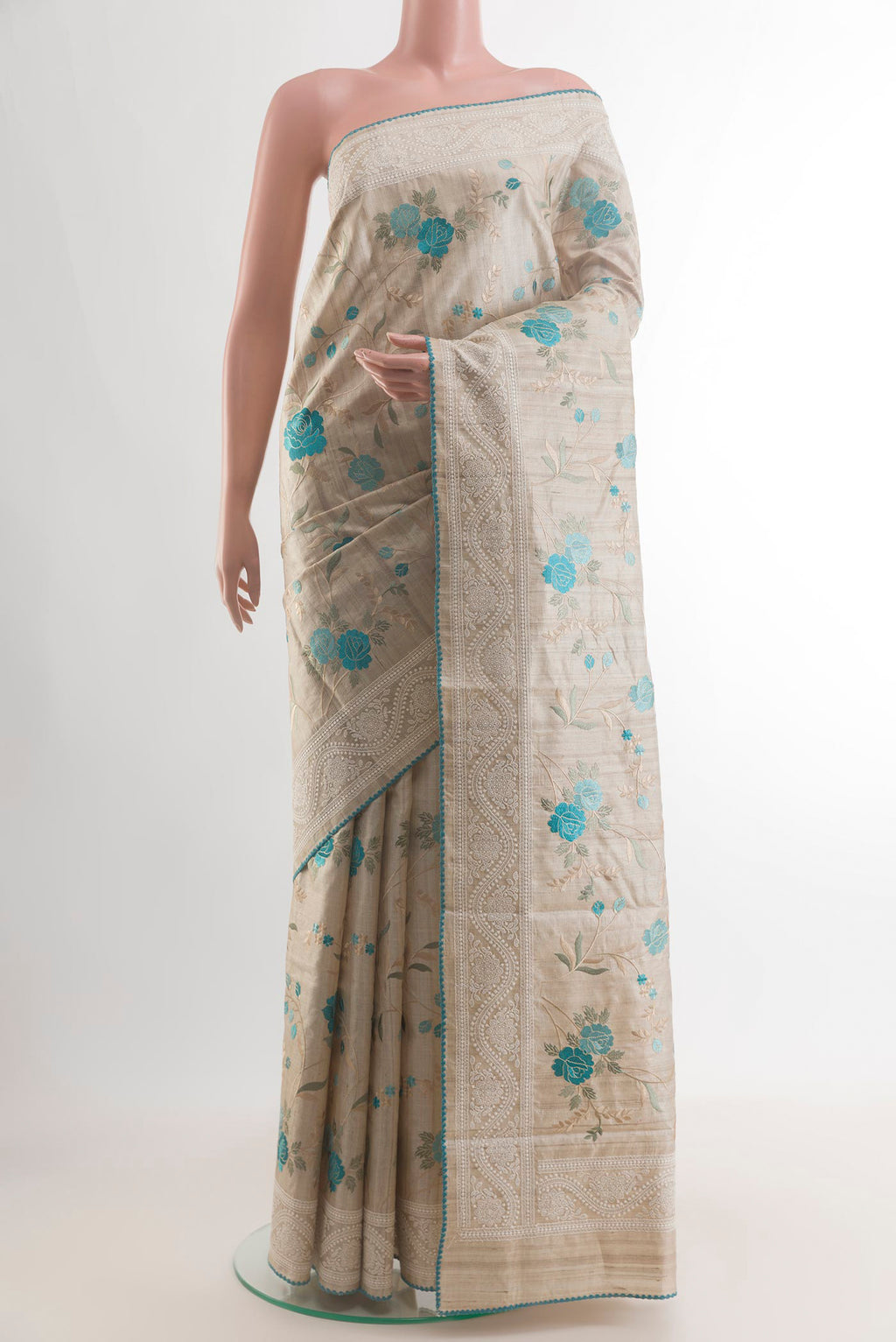 Beige Tussar Saree with Embroidery on the body and Embroidery Border.  displayed on a mannequin