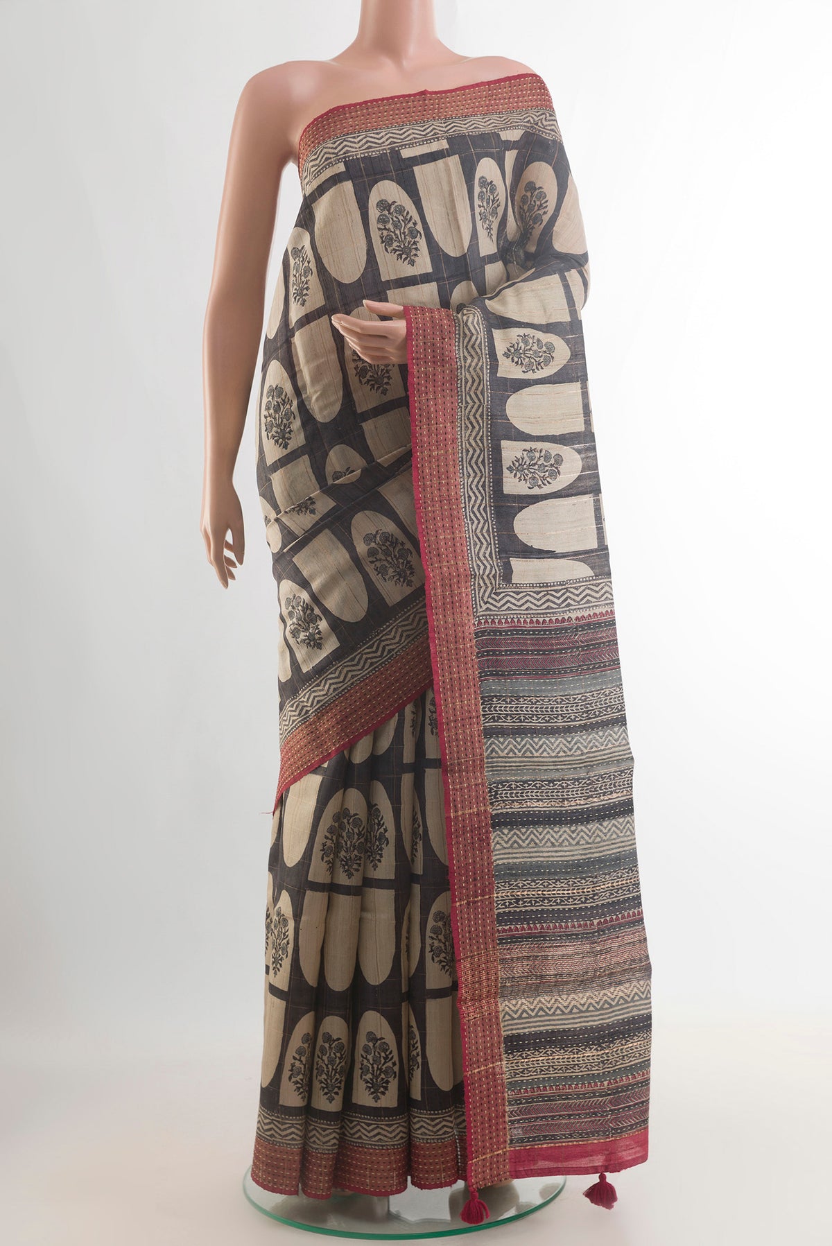 Green Tussar Saree with Printed design on the body and Zari Border.  displayed on a mannequin