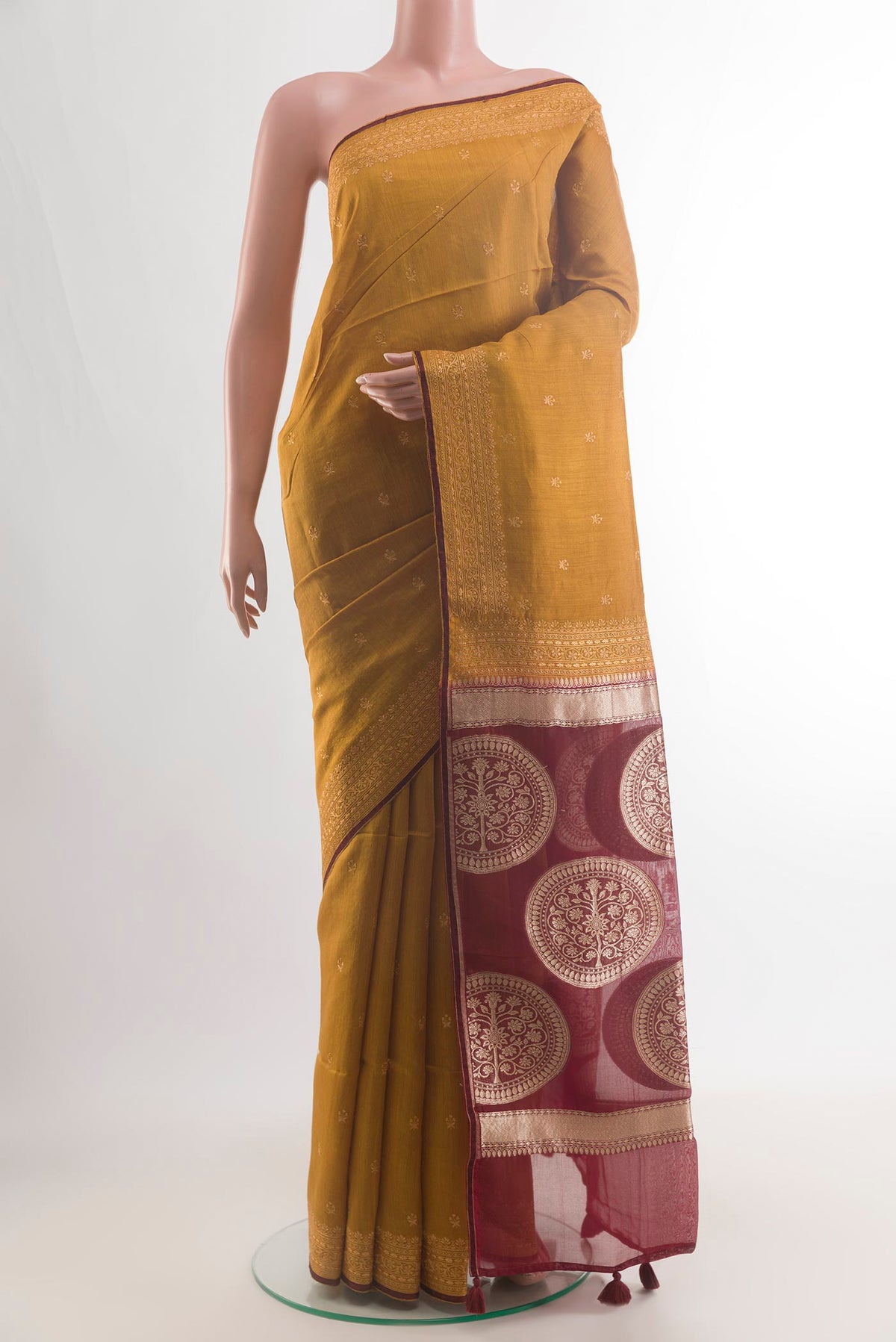 Mustard Tussar Saree with Embroidery on the body and Embroidery Border.  displayed on a mannequin