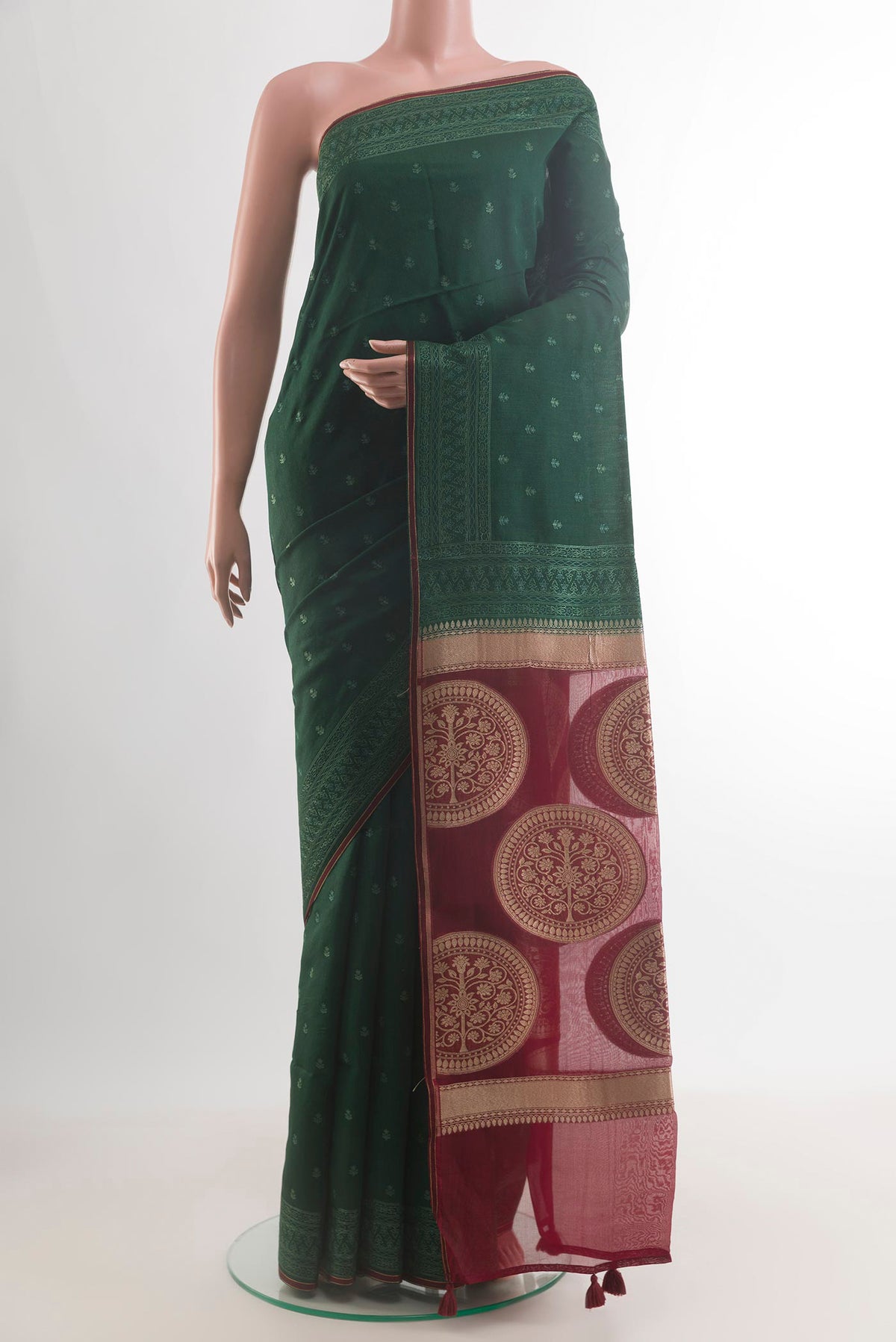 Bottle Green Tussar Saree with Embroidery on the body and Embroidery Border.  displayed on a mannequin