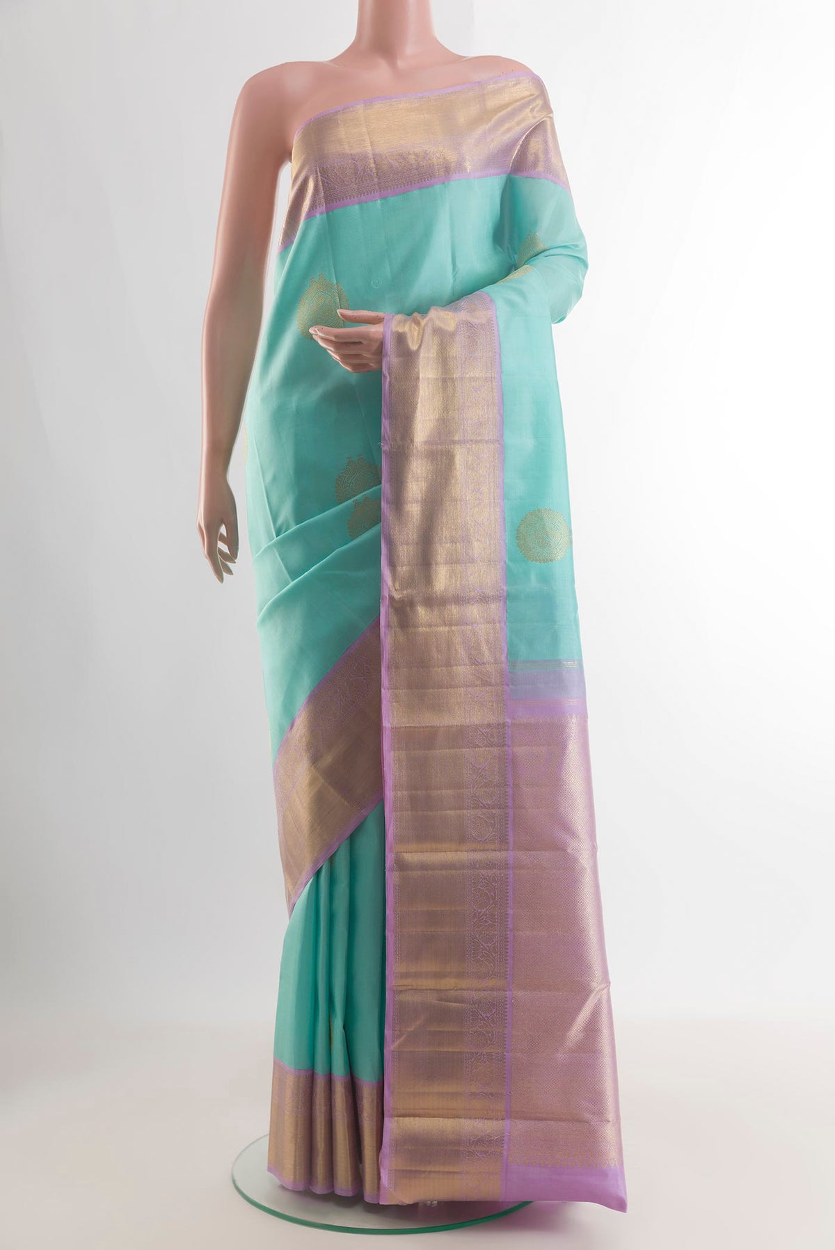 Pure Silk Sea Green Kanchipuram Saree with Zari Butta on the body and Zari Border.  displayed on a mannequin