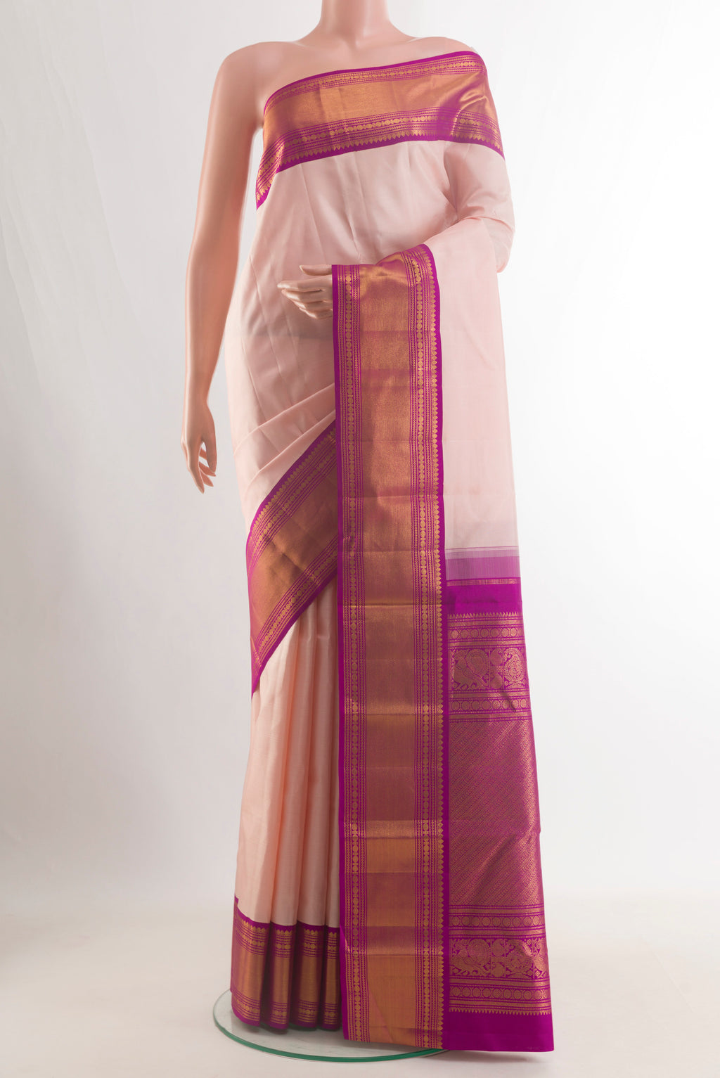 Pure Silk Peach Kanjivaram Saree with Plain Body and Zari Border.  displayed on a mannequin