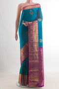 Pure Silk Peacock Blue Kanjivaram Saree with Zari Butta on the body and Zari Border.  displayed on a mannequin