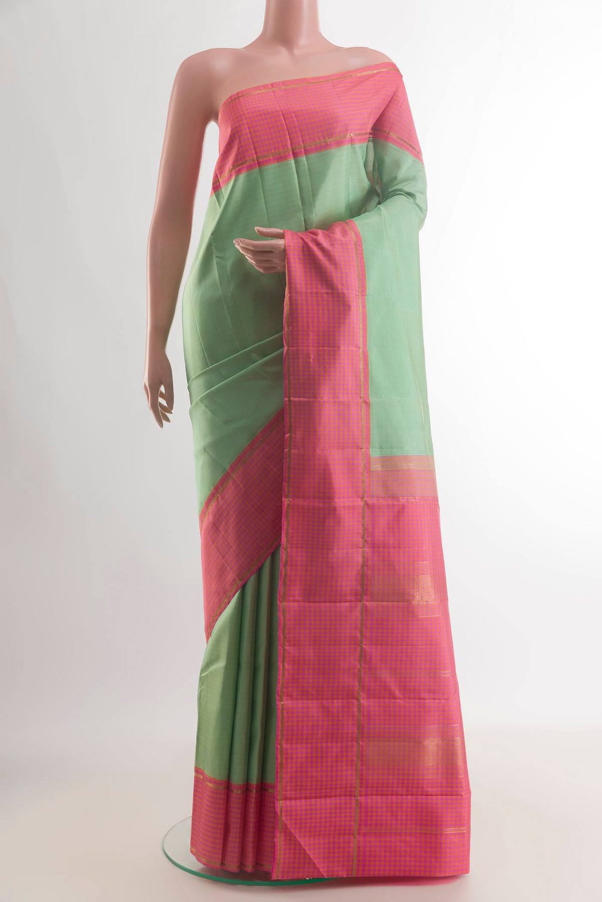Pure Silk Pista Green Kanjivaram Saree with Plain Body and Zari Border.  displayed on a mannequin