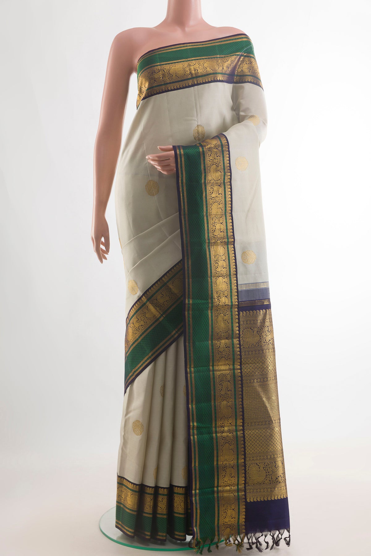 Pure Silk Off White Kanchipuram Saree with Zari Butta on the body and Zari Border.  displayed on a mannequin