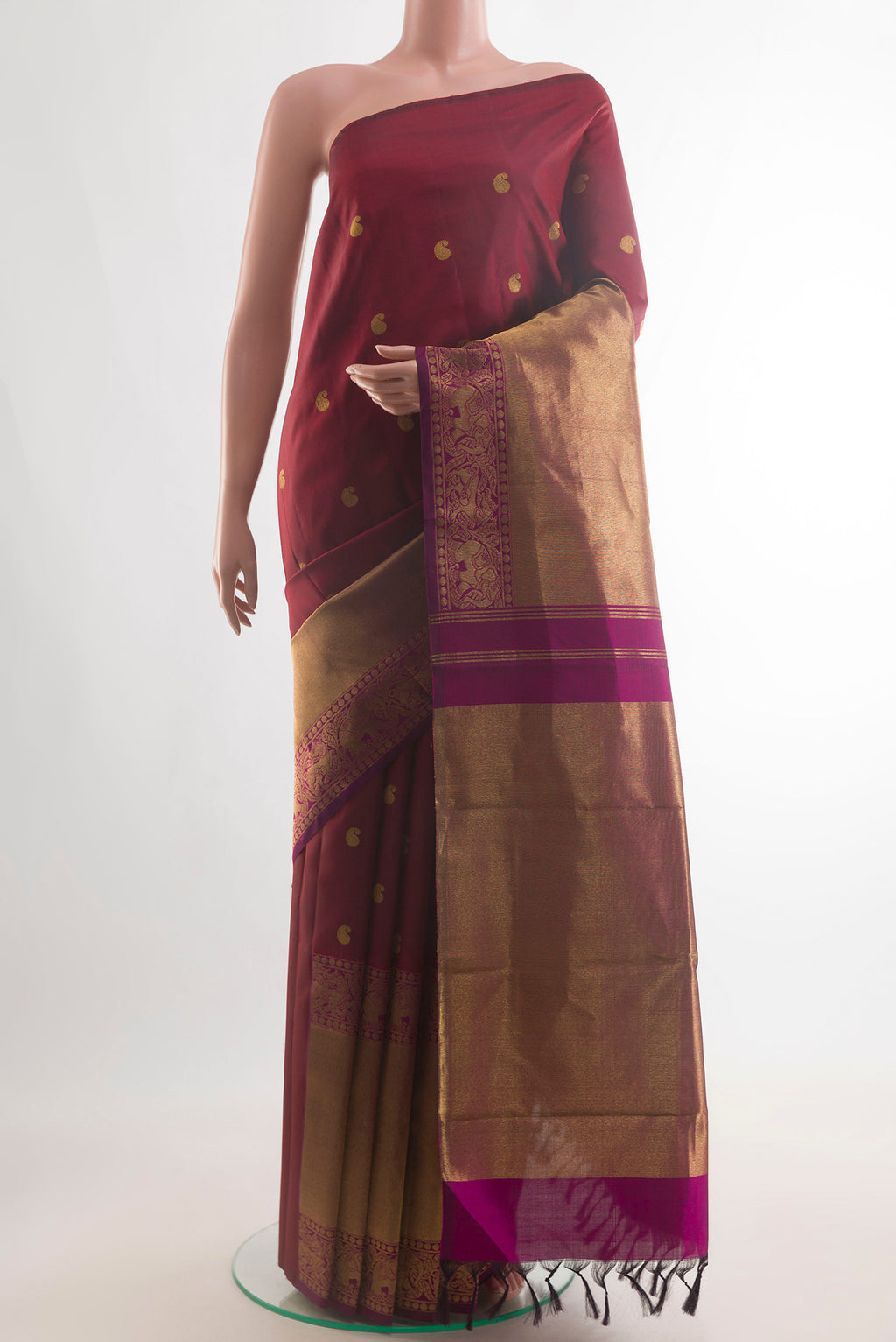 Pure Silk Maroon Kanchipuram Saree with Zari Butta on the body and Zari Border.  displayed on a mannequin