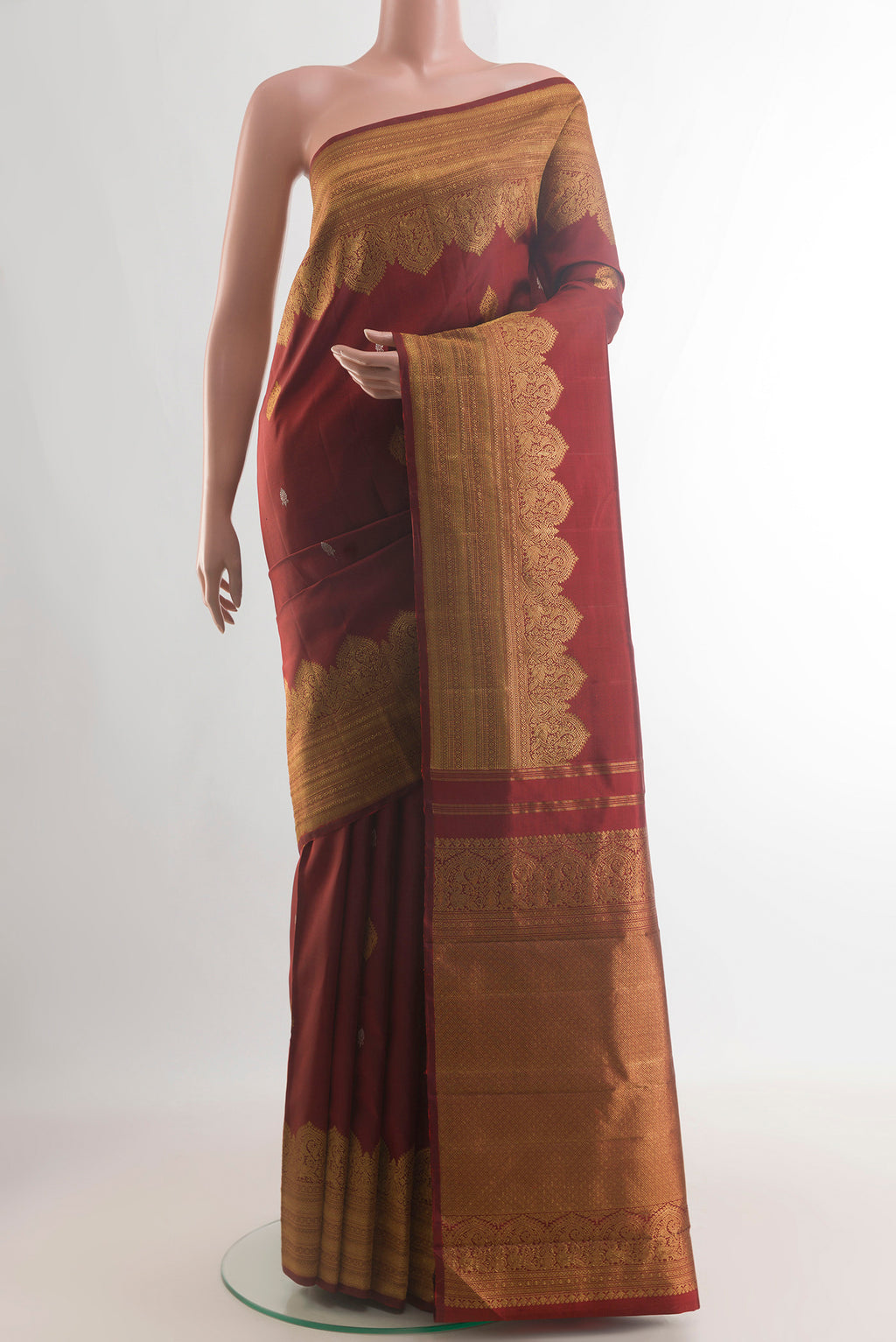 Pure Silk Maroon Kanjivaram Saree with Zari Butta on the body and Zari Border.  displayed on a mannequin