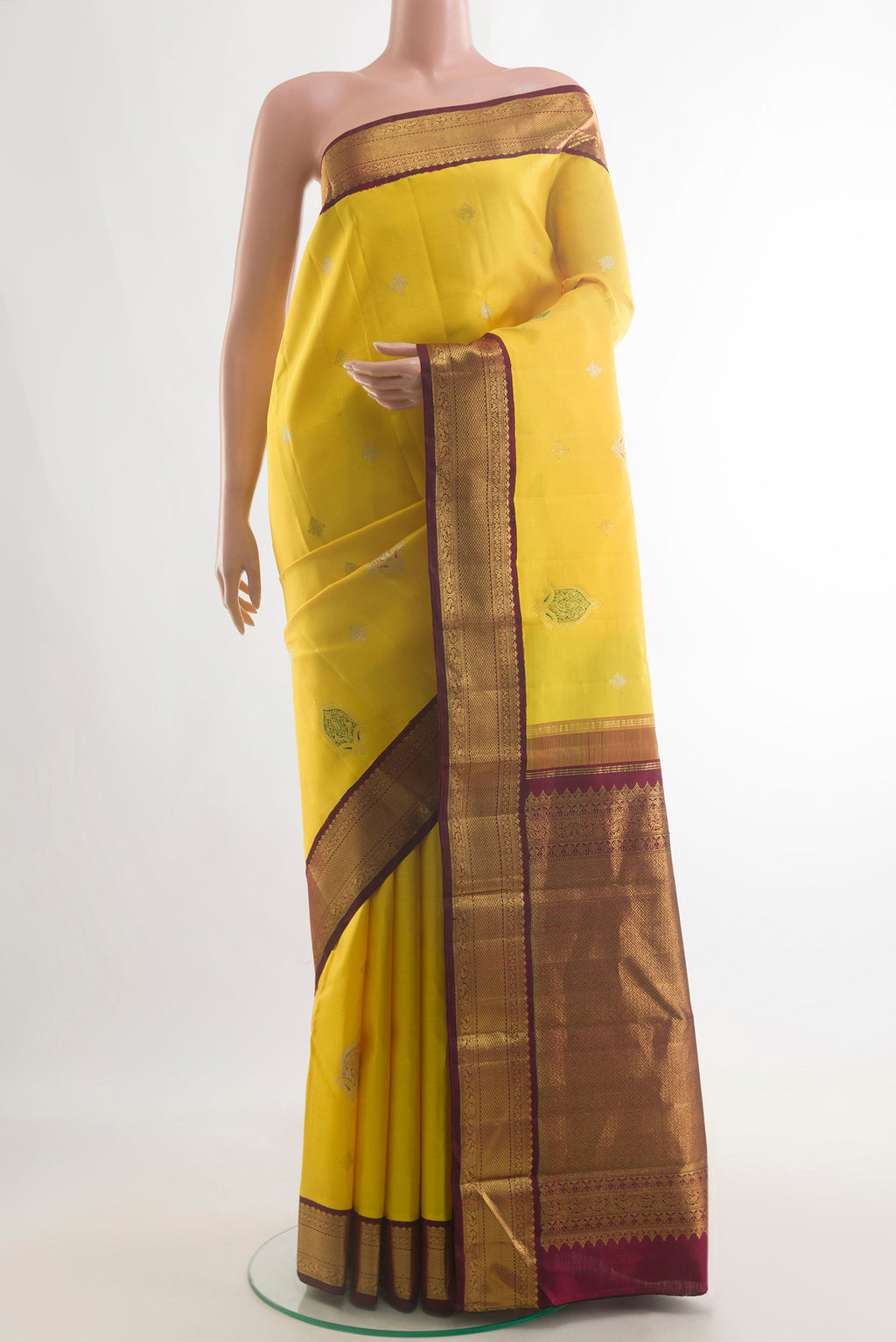 Pure Silk Yellow Kanjivaram Saree with Zari Butta on the body and Zari Border.  displayed on a mannequin