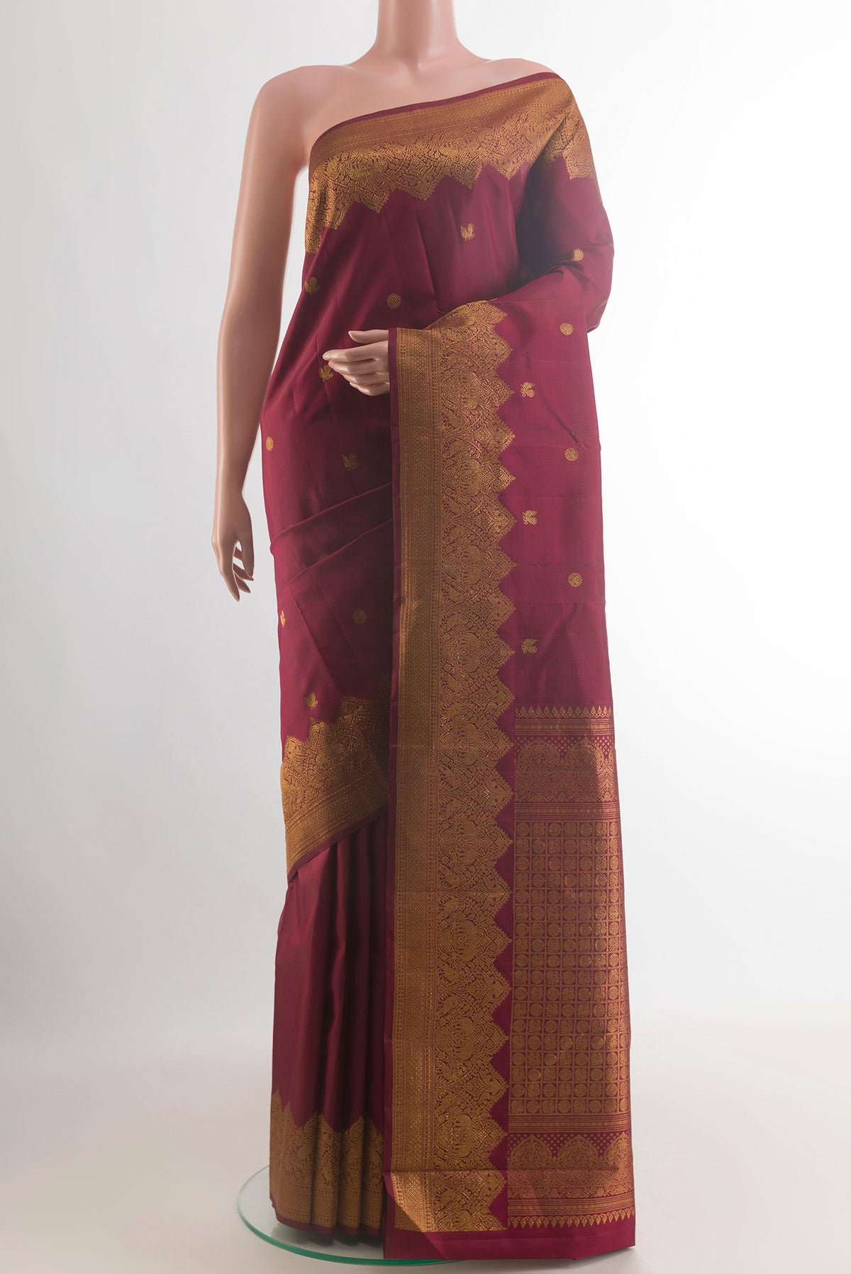 Pure Silk Maroon Kanjivaram Saree with Zari Butta on the body and Zari Border.  displayed on a mannequin