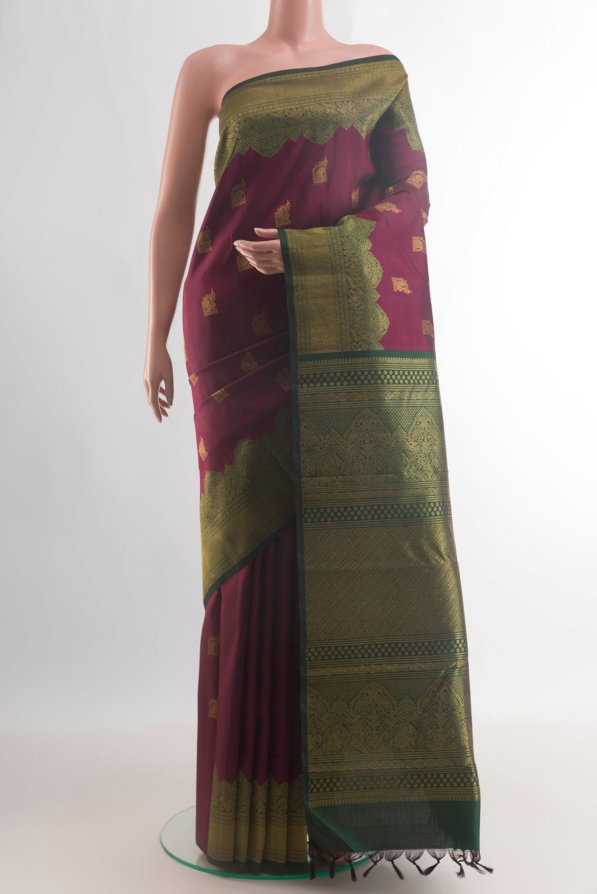 Pure Silk Maroon Kanchipuram Saree with Zari Butta on the body and Fancy Border.  displayed on a mannequin