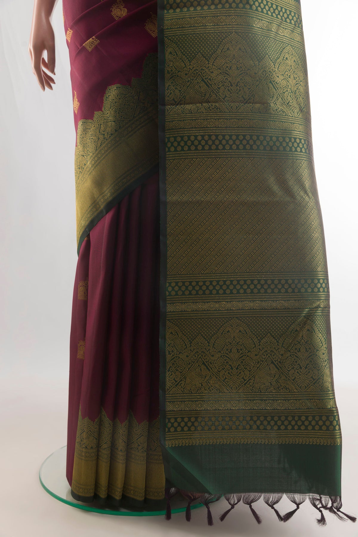 Pleats and pallu of Pure Silk Maroon Kanchipuram Saree with Zari Butta on the body and Fancy Border. 