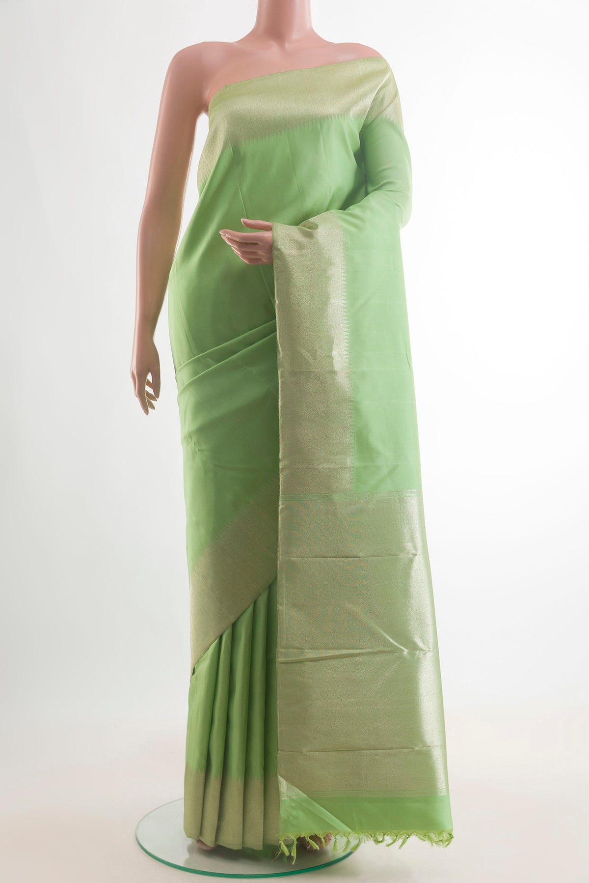 Pure Silk Pista Green Kanchipuram Saree with Plain Body and Zari Border.  displayed on a mannequin