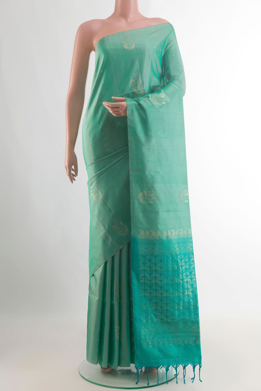 Pure Silk Sea Green Soft Saree with Zari Butta on the body and Without Border.  displayed on a mannequin