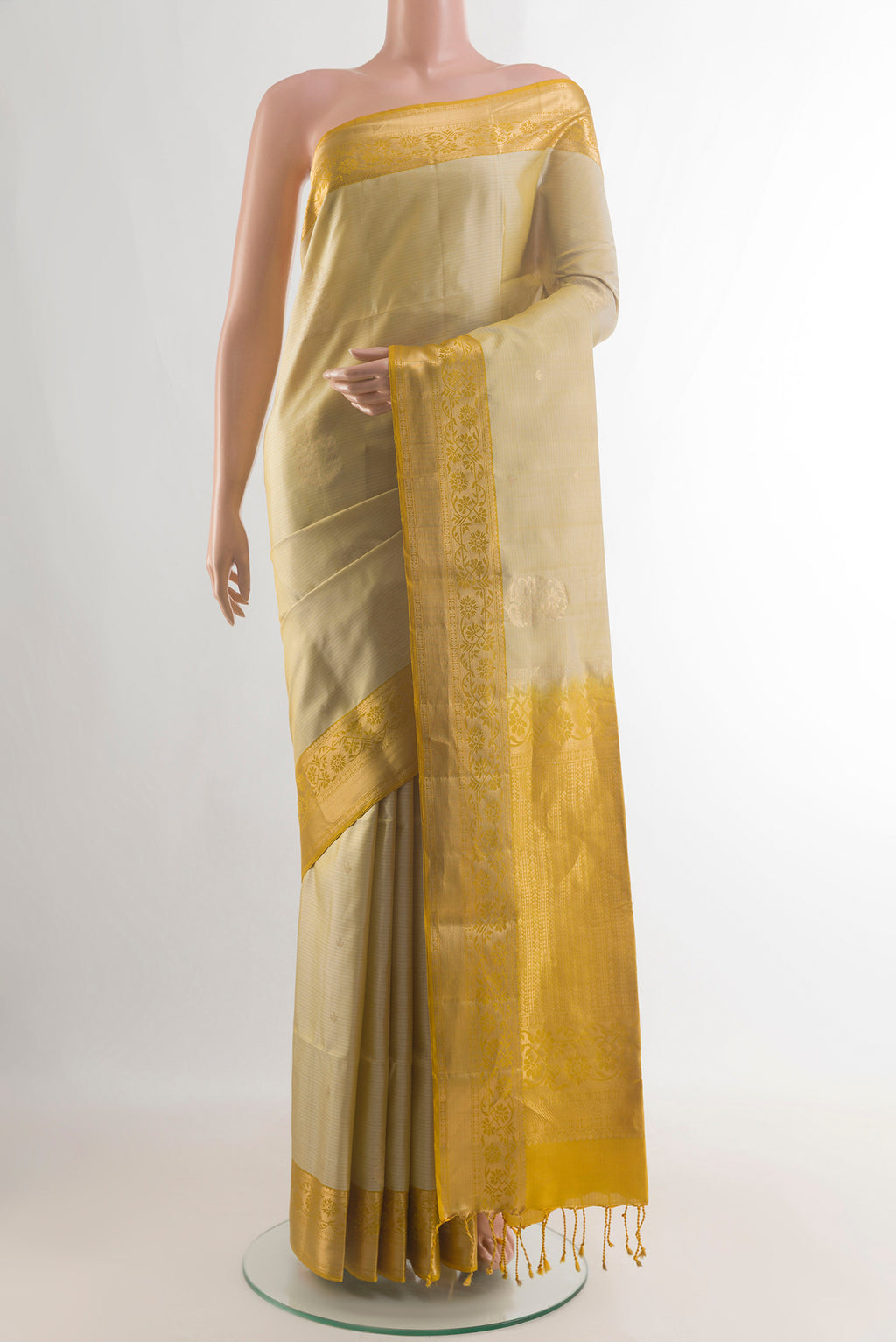 Pure Silk Beige Soft Saree with Zari Butta on the body and Zari Border.  displayed on a mannequin
