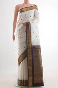 Pure Silk White Kanchipuram Saree with Thread Butta on the body and Zari Border.  displayed on a mannequin