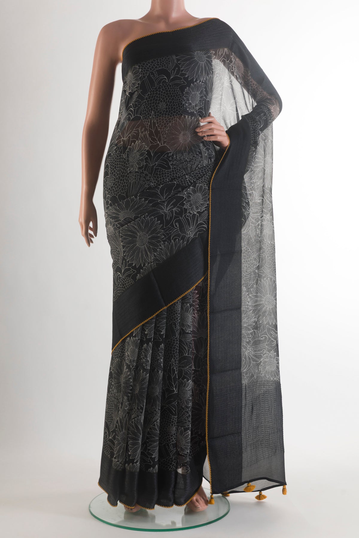 Black Tussar Saree with Printed design on the body and Plain Border.  displayed on a mannequin