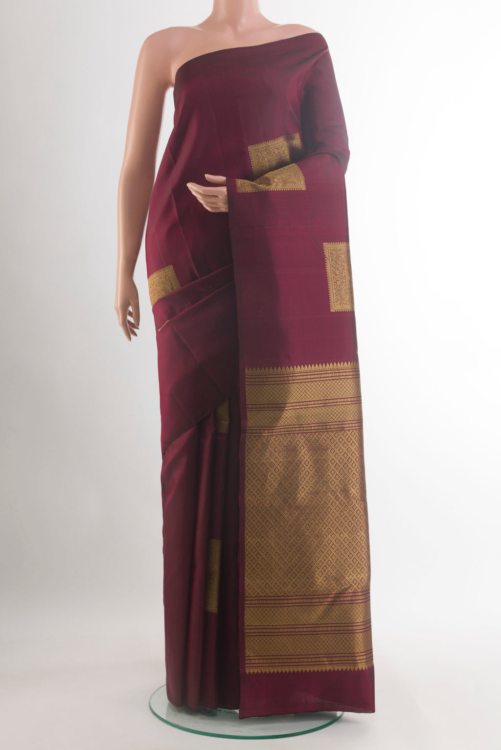 Pure Silk Maroon Kanchipuram Saree with Zari Butta on the body and Without Border.  displayed on a mannequin
