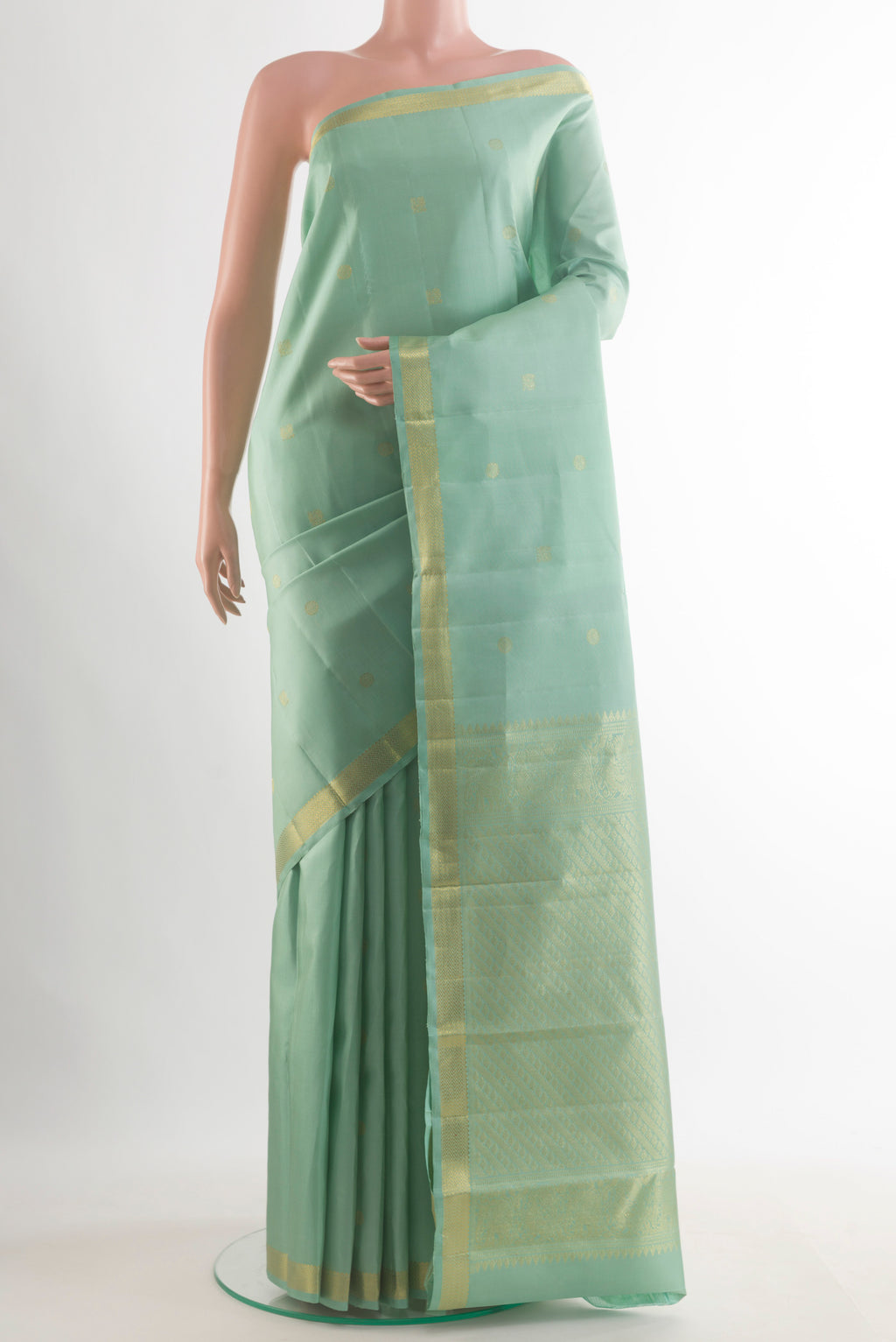 Pure Silk Mint Green Kanchipuram Saree with Zari Butta on the body and Zari Border.  displayed on a mannequin