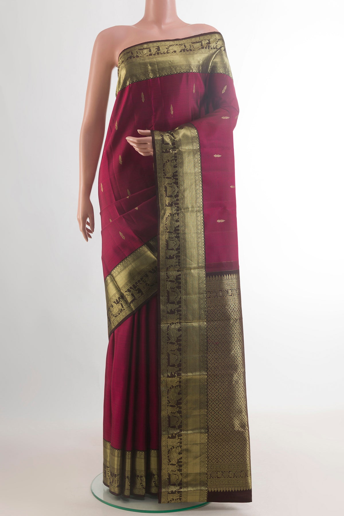 Pure Silk Maroon Kanchipuram Saree with Zari Butta on the body and Zari Border.  displayed on a mannequin