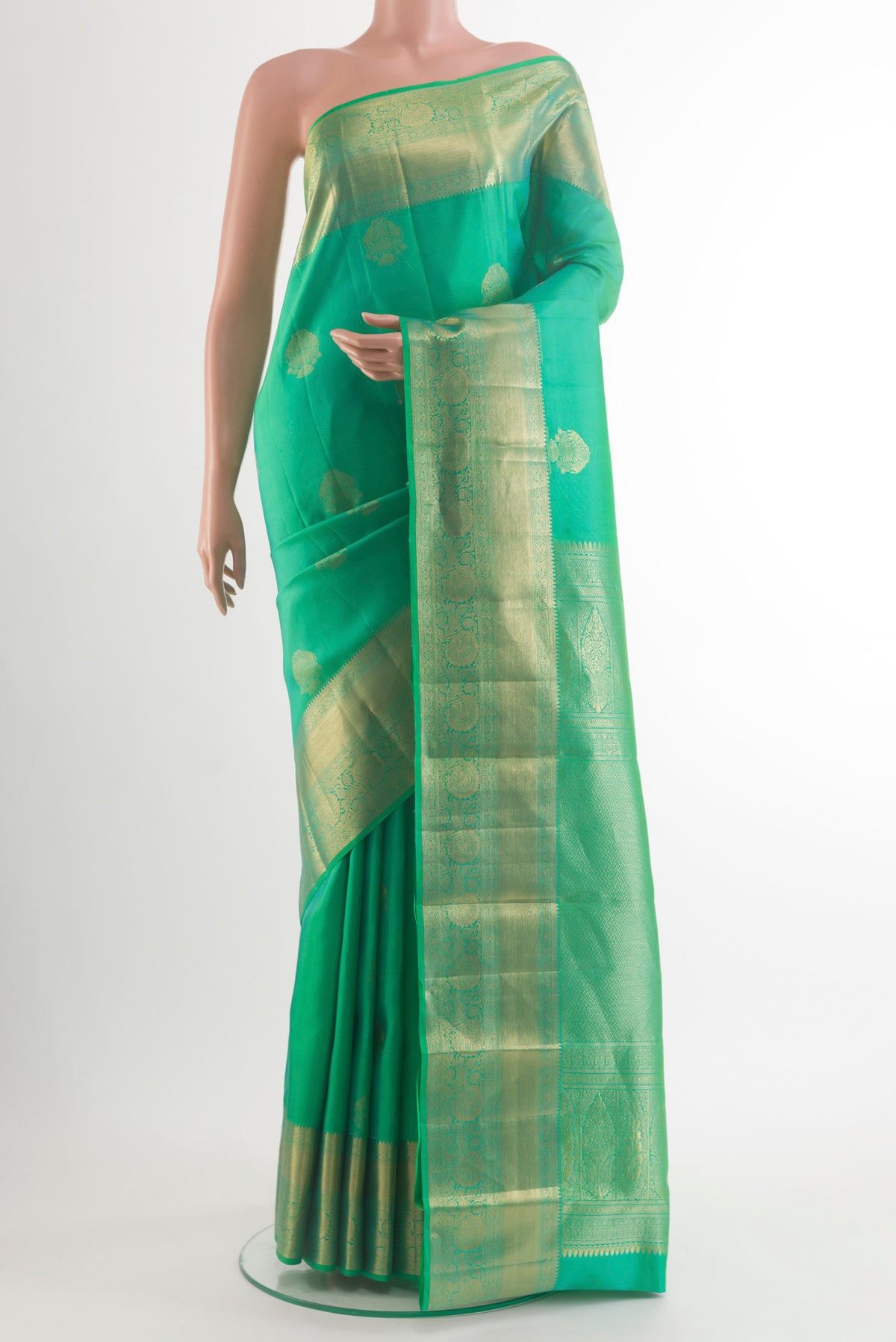 Pure Silk Green Kanjivaram Saree with Zari Butta on the body and Zari Border.  displayed on a mannequin