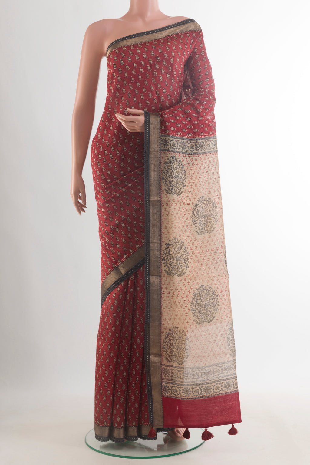 Rust Tussar Saree with Printed design on the body and Zari Border.  displayed on a mannequin