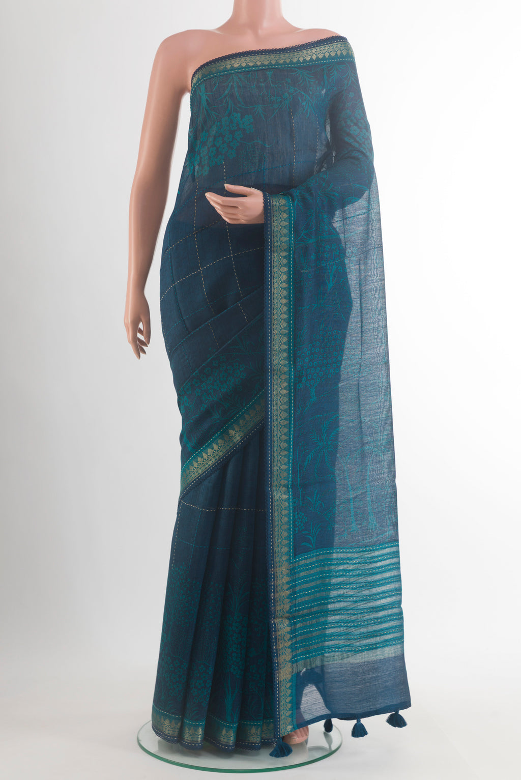 Teal Tussar Saree with Printed design on the body and Zari Border.  displayed on a mannequin