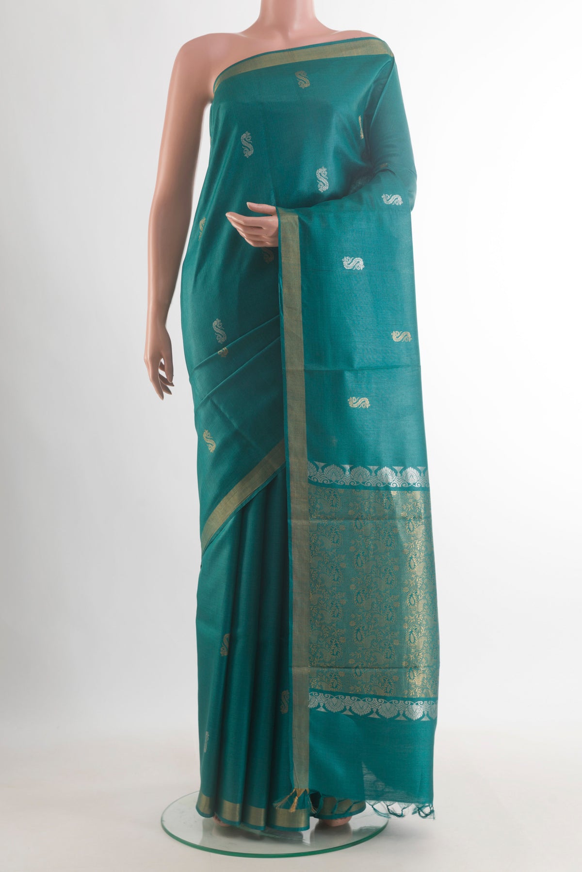 Teal Tussar Saree with Zari Butta on the body and Zari Border.  displayed on a mannequin
