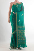 Green Tussar Saree with Zari Butta on the body and Zari Border.  displayed on a mannequin