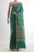 Green Tussar Saree with Zari Butta on the body and Zari Border.  displayed on a mannequin