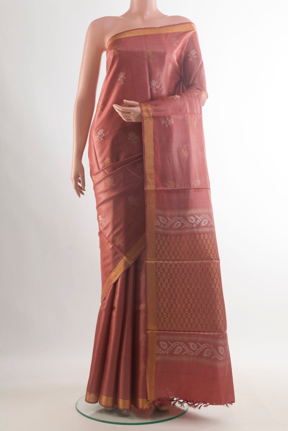 Rust Tussar Saree with Zari Butta on the body and Zari Border.  displayed on a mannequin