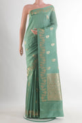 Pure Silk Sage Green Banarasi Katan Saree with Zari Butta on the body and Zari Border.  displayed on a mannequin