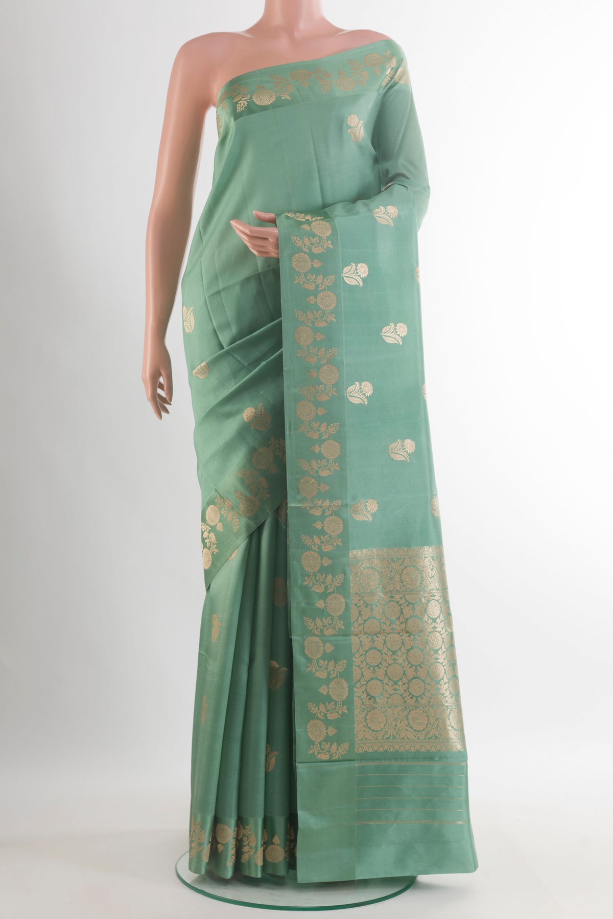 Pure Silk Sage Green Banarasi Katan Saree with Zari Butta on the body and Zari Border.  displayed on a mannequin