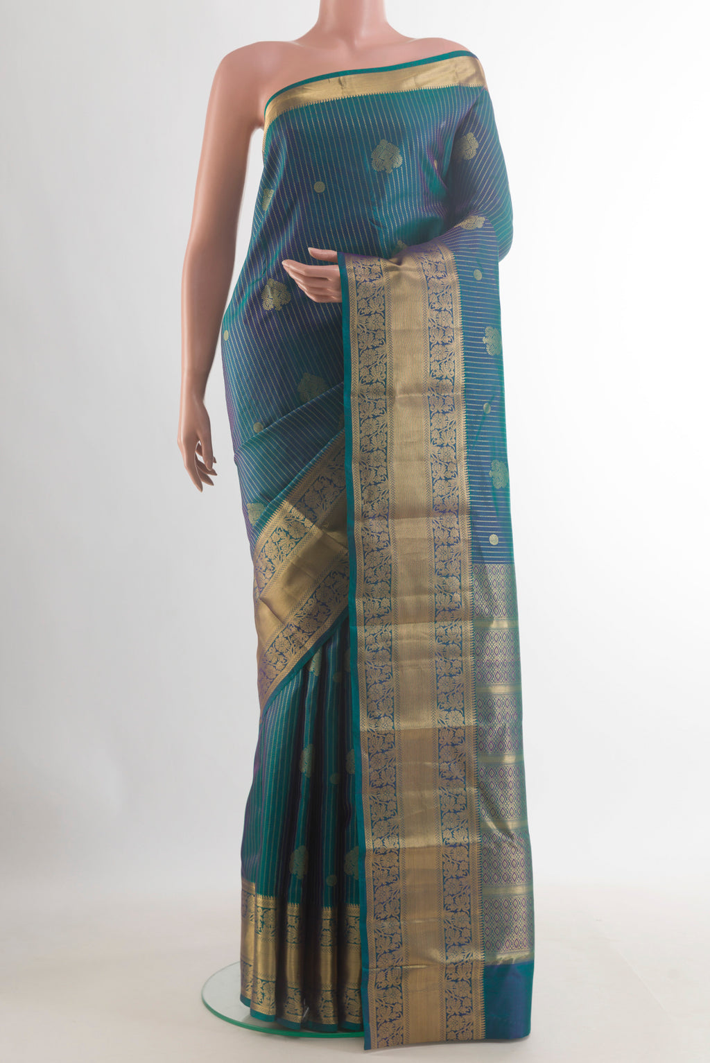 Pure Silk Peacock Blue Kanchipuram Saree with Zari Butta on the body and Zari Border.  displayed on a mannequin