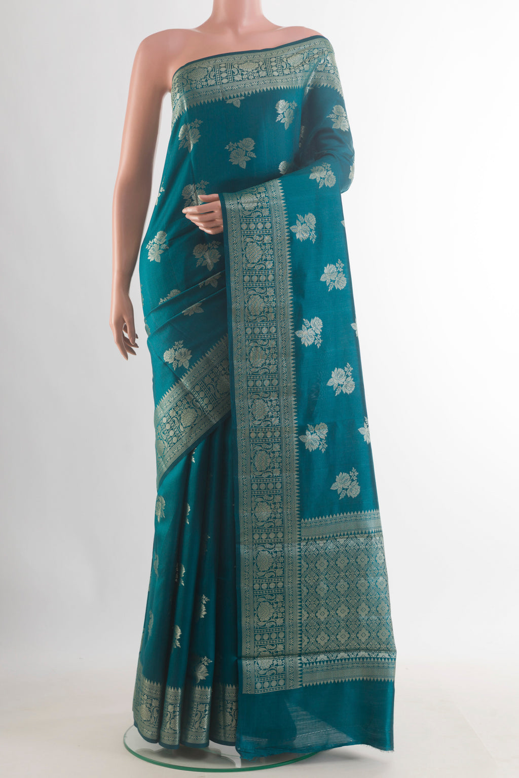 Teal Tussar Saree with Zari Butta on the body and Zari Border.  displayed on a mannequin