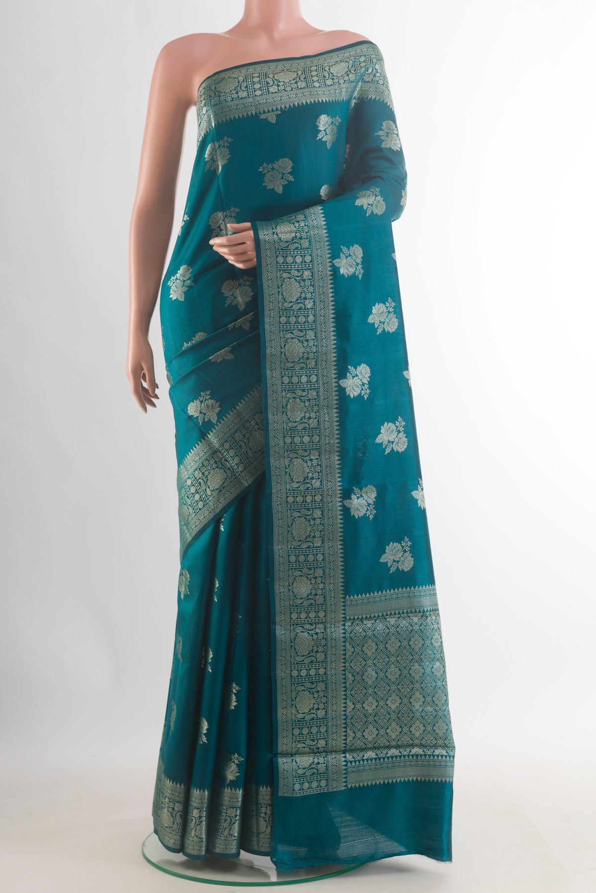 Teal Tussar Saree with Zari Butta on the body and Zari Border.  displayed on a mannequin