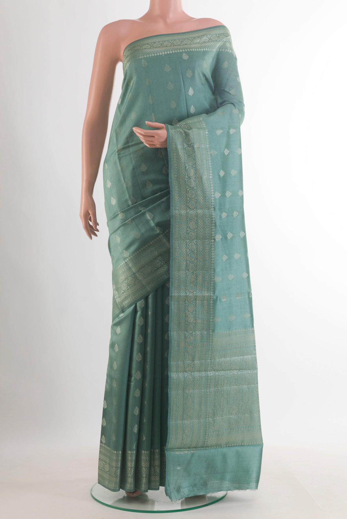 Sage Green Tussar Saree with Zari Butta on the body and Zari Border.  displayed on a mannequin