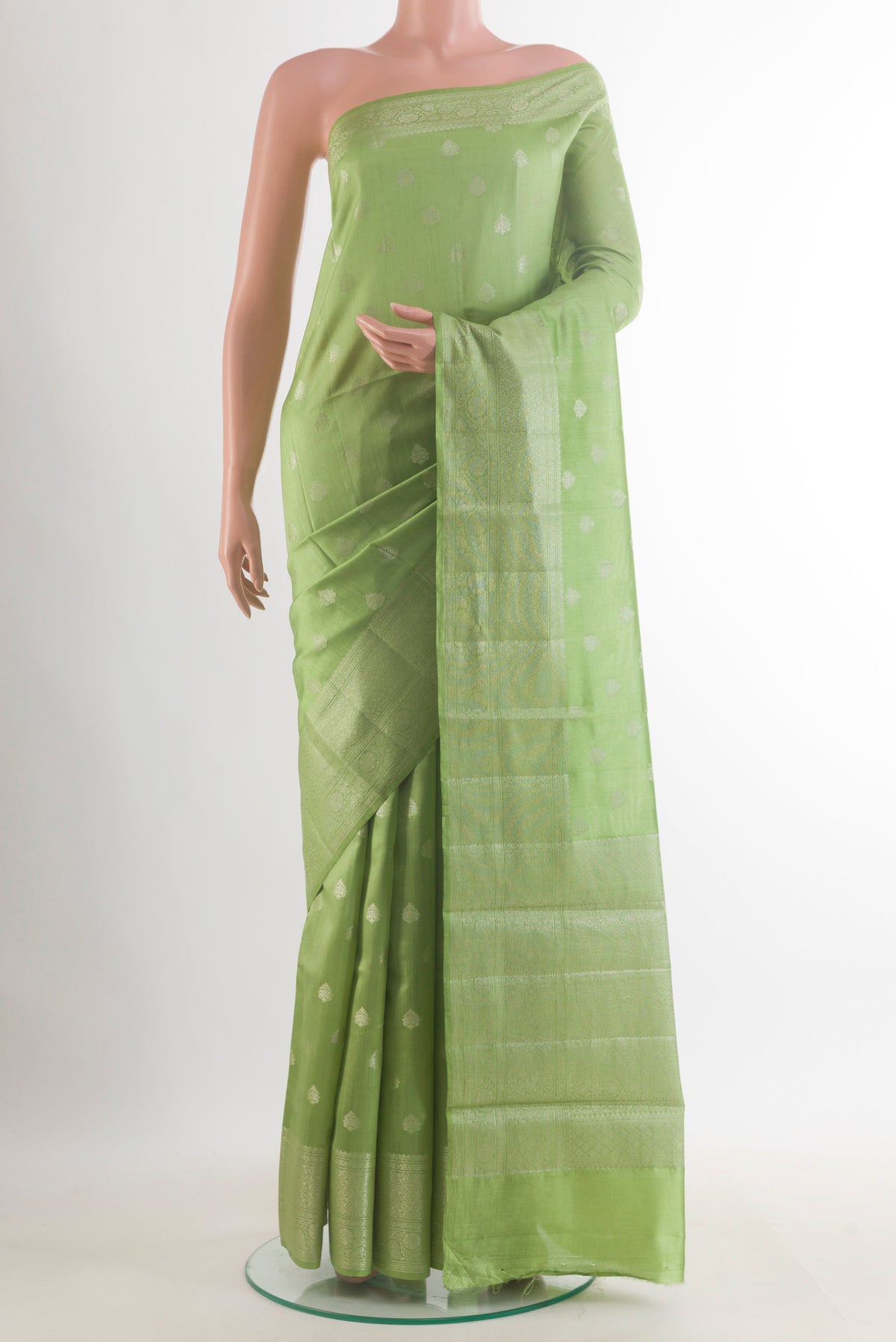 Green Tussar Saree with Zari Butta on the body and Zari Border.  displayed on a mannequin