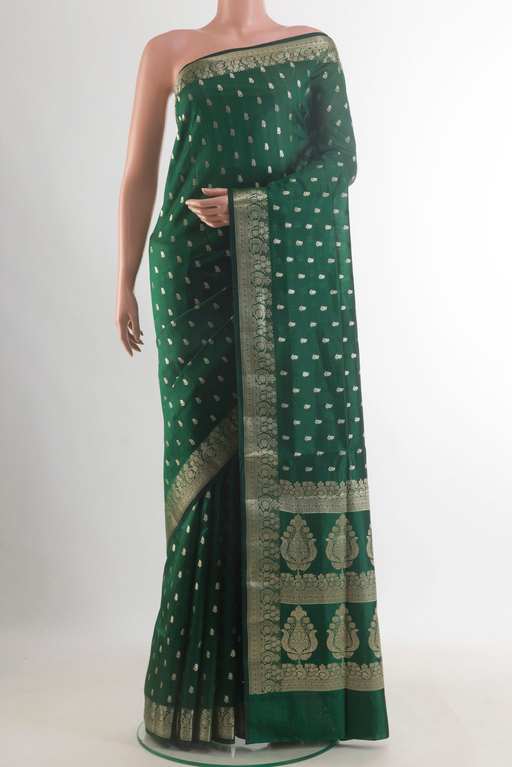 Pure Silk Bottle Green Banarasi Raw Saree with Zari Butta on the body and Zari Border.  displayed on a mannequin