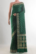 Pure Silk Bottle Green Banarasi Raw Saree with Zari Butta on the body and Zari Border.  displayed on a mannequin