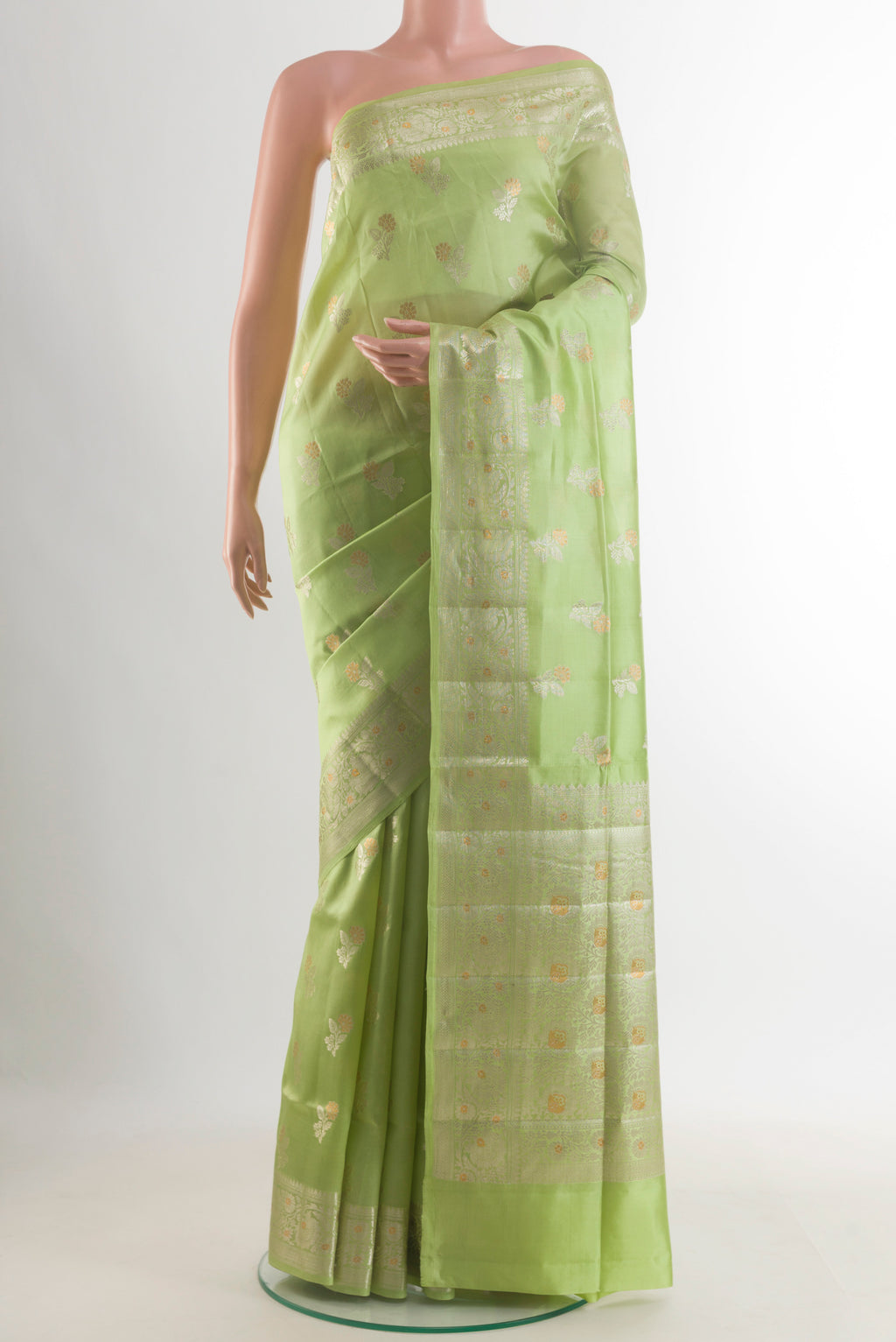 Pure Silk Pista Green Banarasi Raw Saree with Zari Butta on the body and Zari Border.  displayed on a mannequin