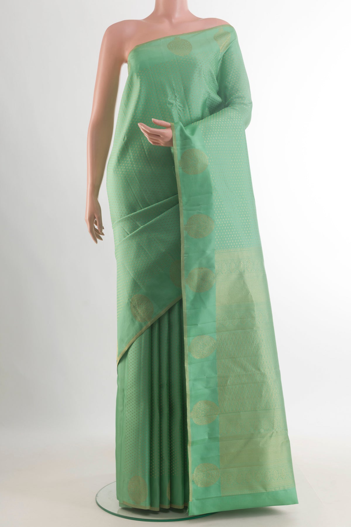 Pure Silk Green Kanchipuram Saree with Zari Butta on the body and Zari Border.  displayed on a mannequin