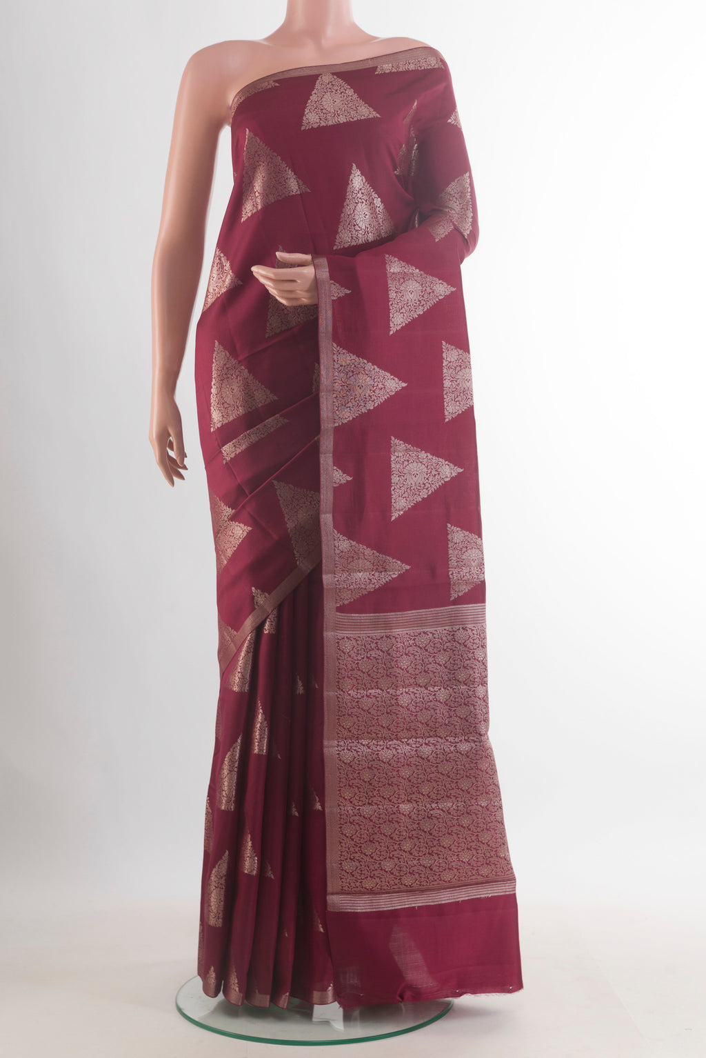 Maroon Tussar Saree with Zari Butta on the body and Zari Border.  displayed on a mannequin