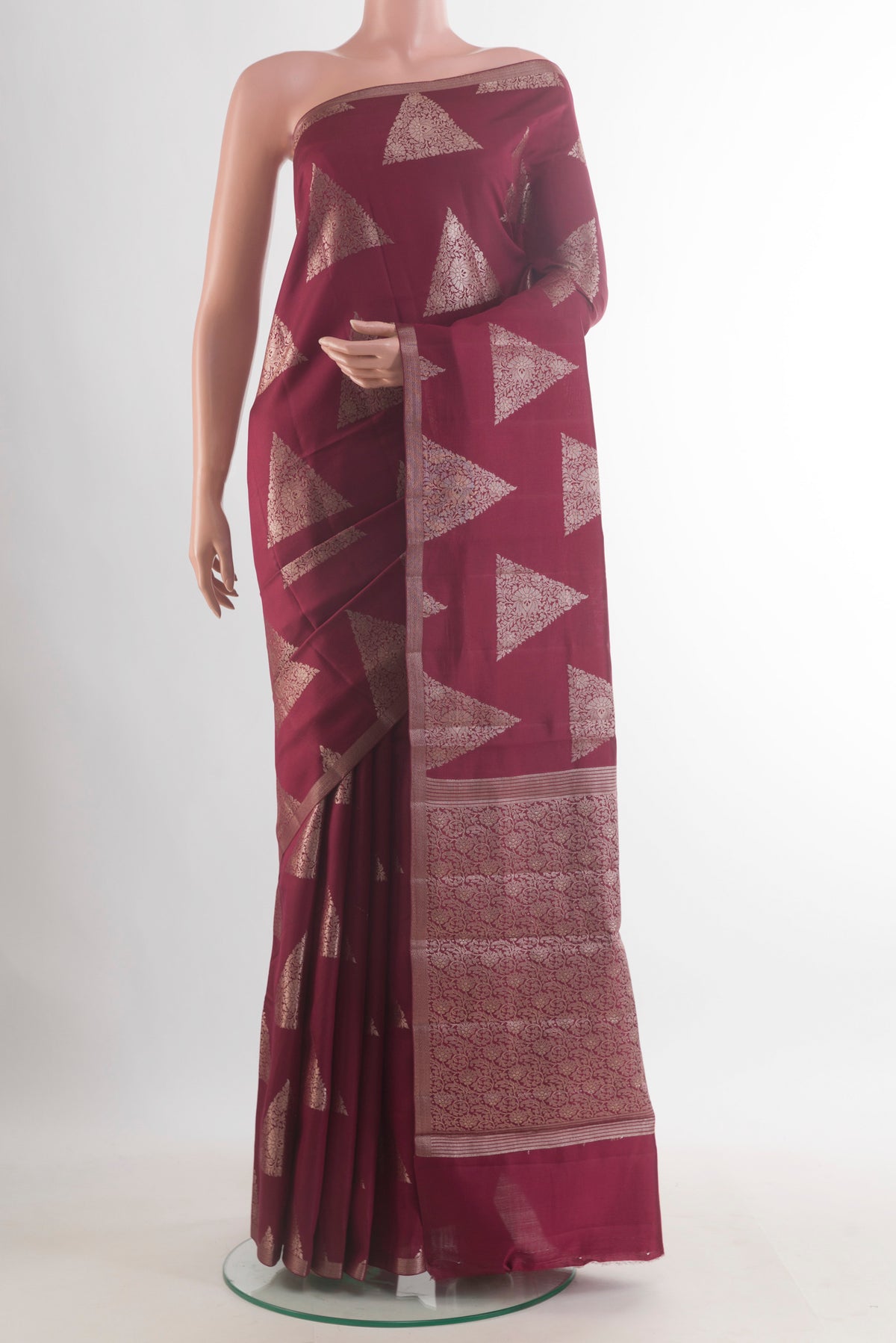 Maroon Tussar Saree with Zari Butta on the body and Zari Border.  displayed on a mannequin