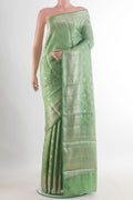 Green Tussar Saree with Zari Brocade on the body and Zari Border.  displayed on a mannequin