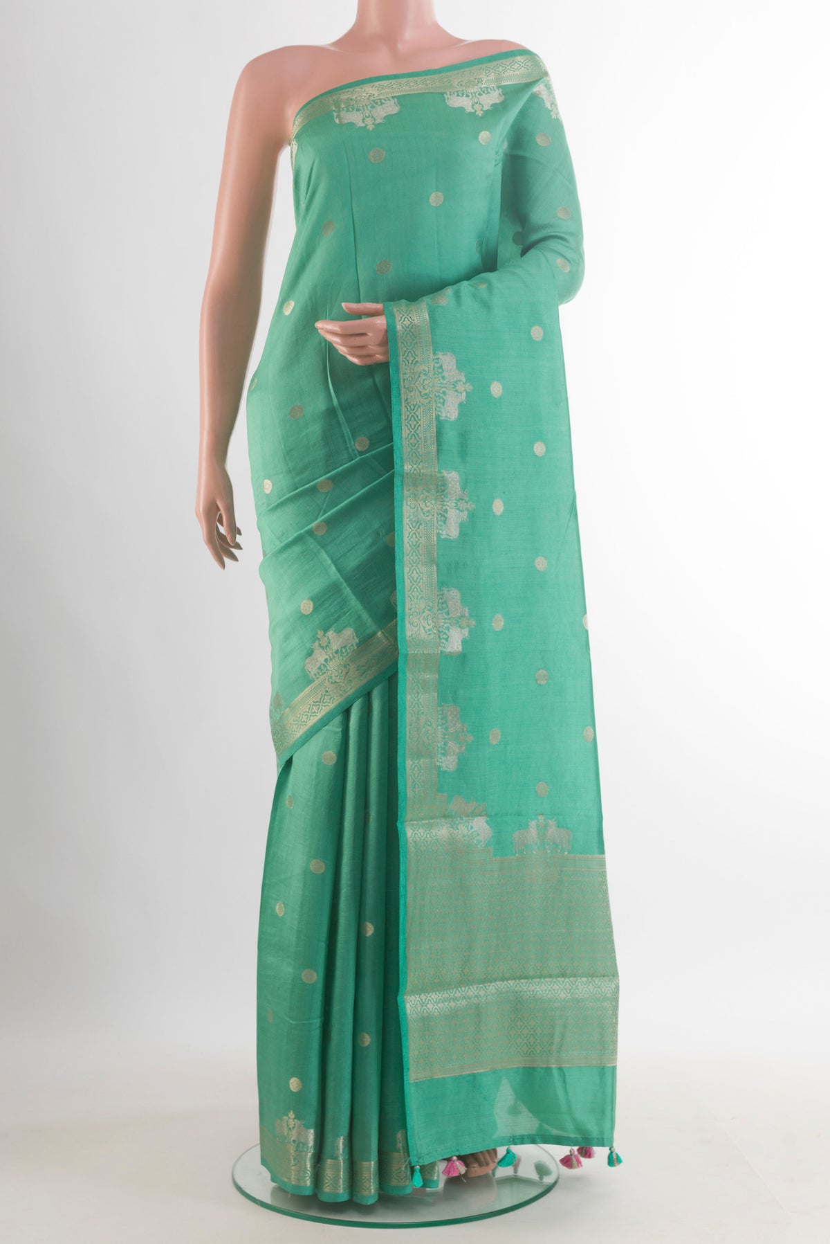 Green Tussar Saree with Zari Butta on the body and Zari Border.  displayed on a mannequin