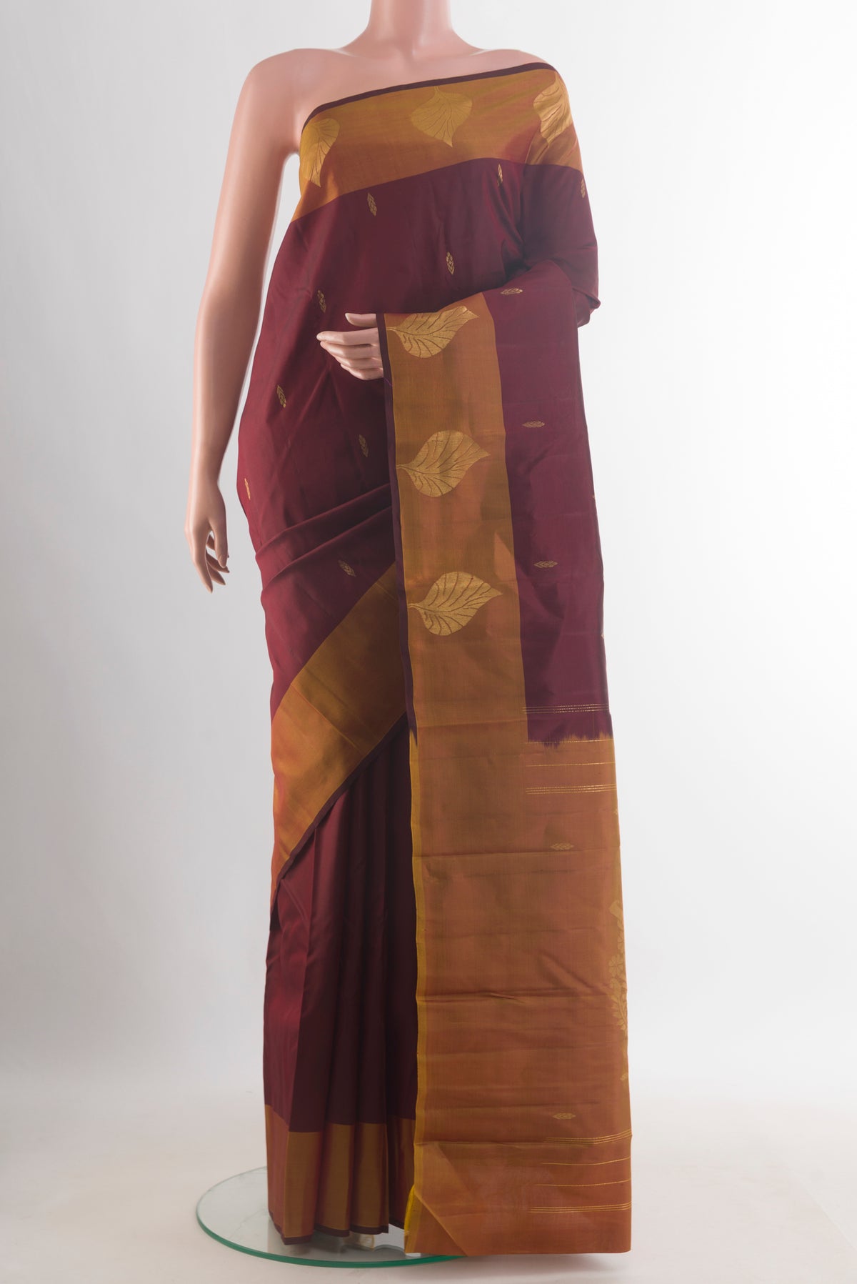 Pure Silk Brown Kanchipuram Saree with Zari Butta on the body and Zari Border.  displayed on a mannequin