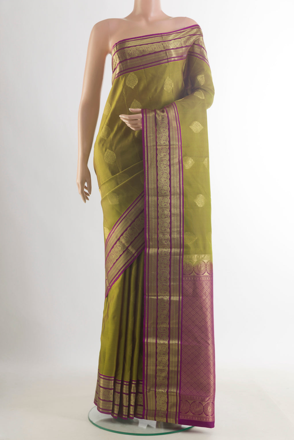 Pure Silk Mehandi Green Kanchipuram Saree with Zari Butta on the body and Zari Border.  displayed on a mannequin