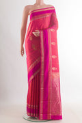 Pure Silk Coral Kanchipuram Saree with Zari Butta on the body and Zari Border.  displayed on a mannequin