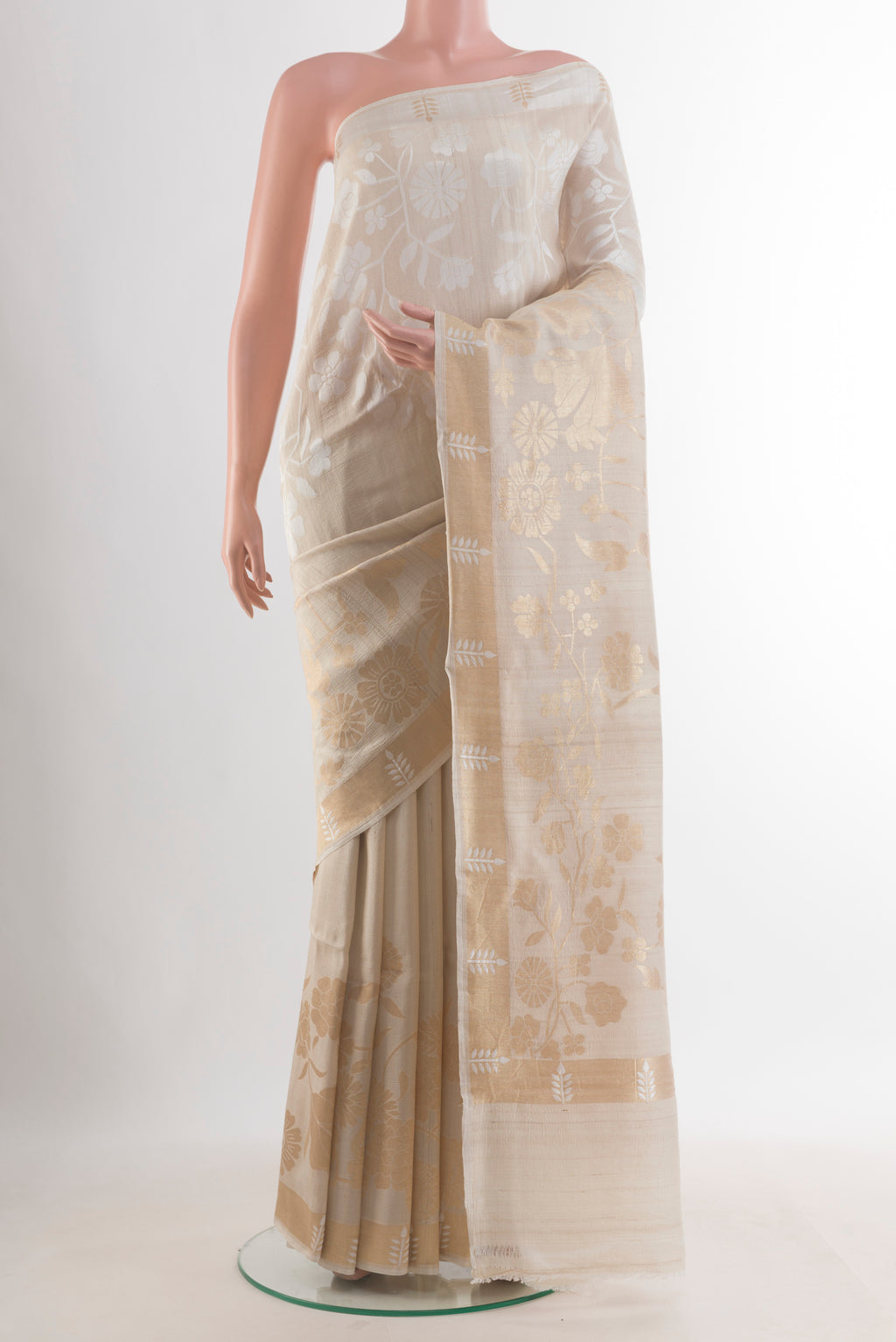 Off White Tussar Saree with Zari Butta on the body and Zari Border.  displayed on a mannequin